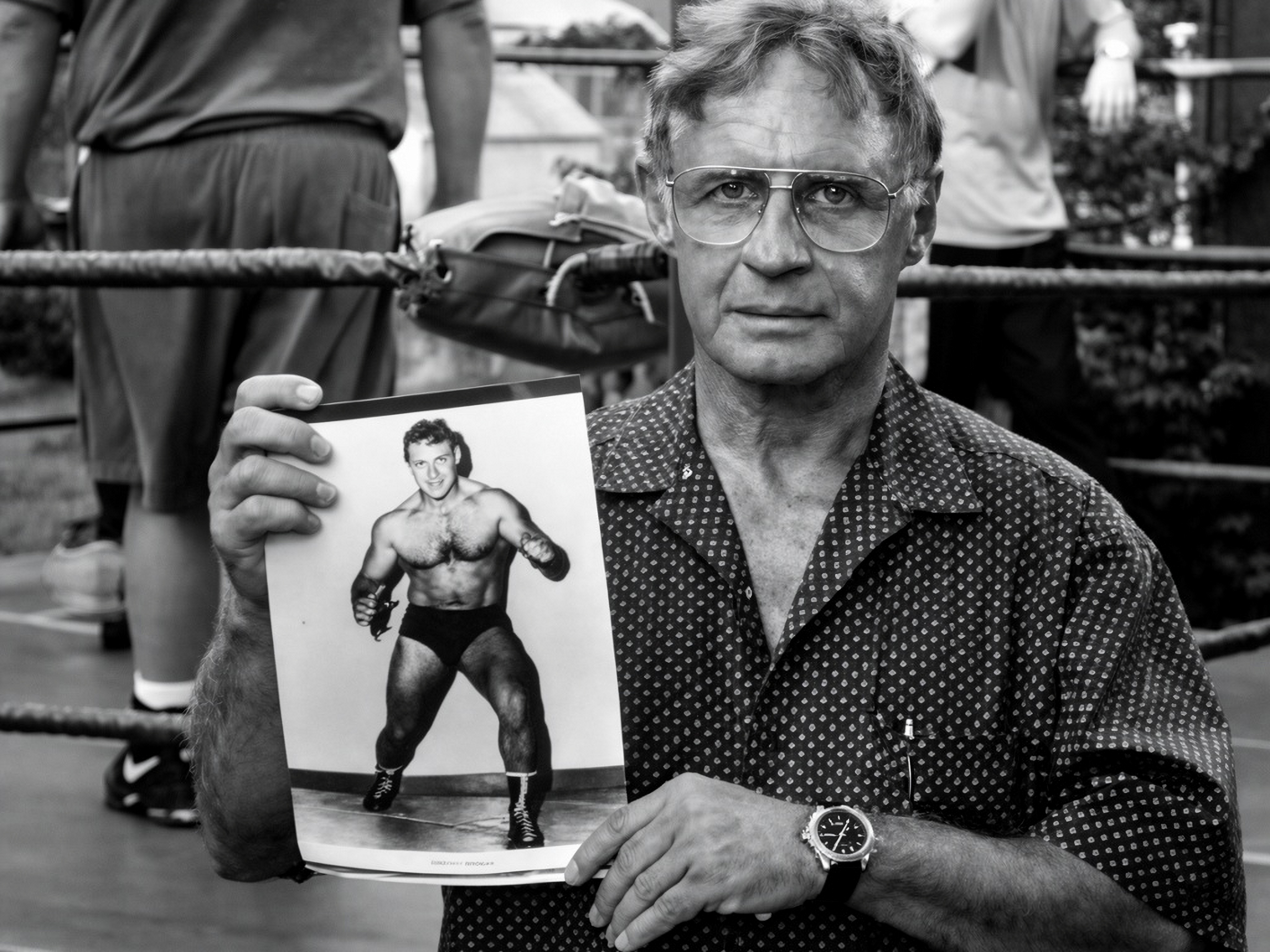 Eddie Sharkey holding a photograph of himself as a young wrestler